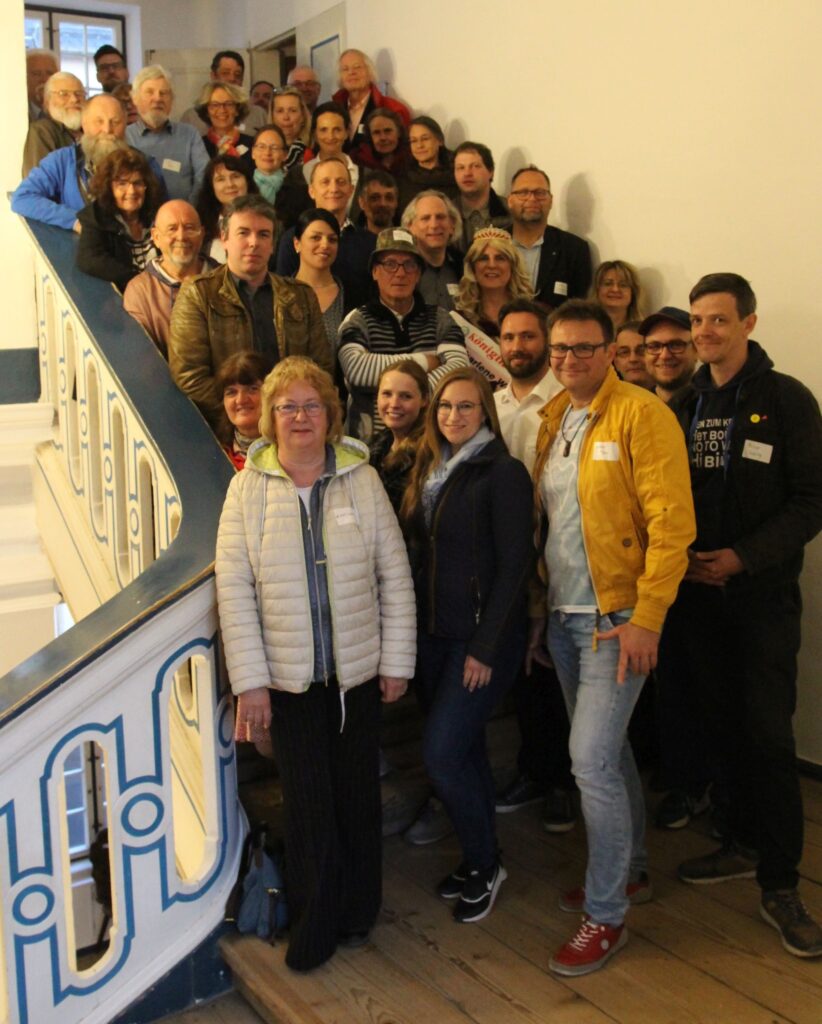 Kulturakteure, die auf einer Treppe für ein Foto posieren.