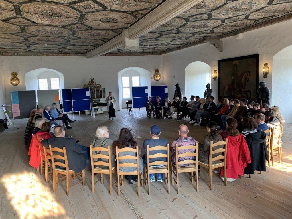 Kulturakteure sitzen im Kreis und hören der Kulturwissenschaftlerin Dr. Beate Kegler zum Thema Kulturentwicklung in Saale-Orla zu.